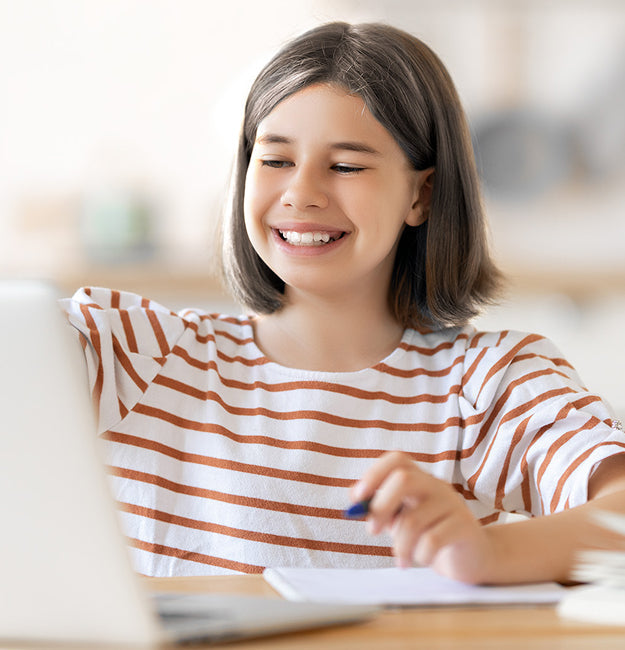 Student girl in a striped shirt smiling and using a laptop